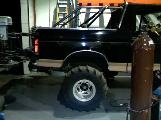 1989 Ford Bronco side view, showing roll cage and oversized mud tires
