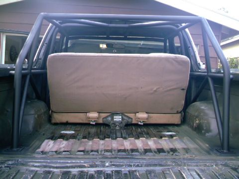 1989 Ford Bronco - Roll cage and rear seat are visible inside the bed of a pickup truck.