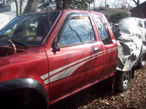 1995 Toyota Tacoma - This red 1995 Toyota Tacoma pickup truck features white racing stripes along its side.