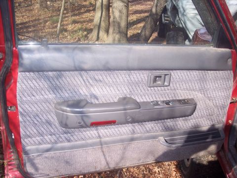 1995 Toyota Tacoma - Close-up view of the interior door panel with fabric upholstery and power window switches.