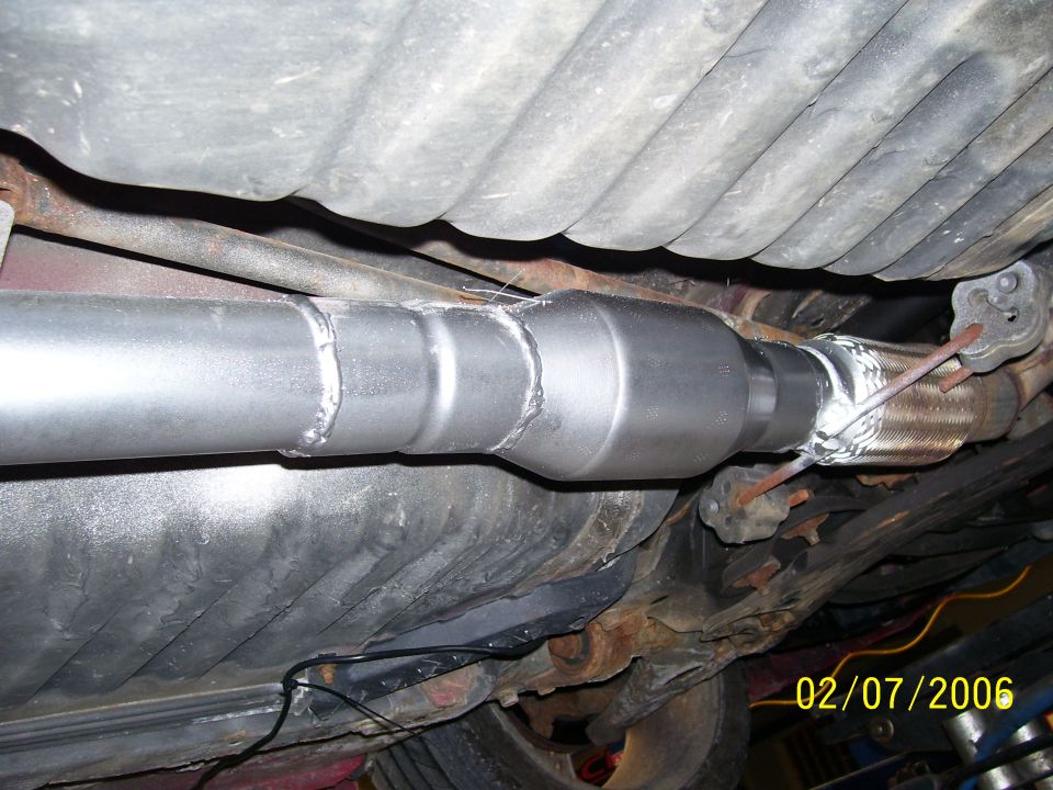 Underbody exhaust with new welded pipe joined to braided flex coupling, dated 02/07/2006.