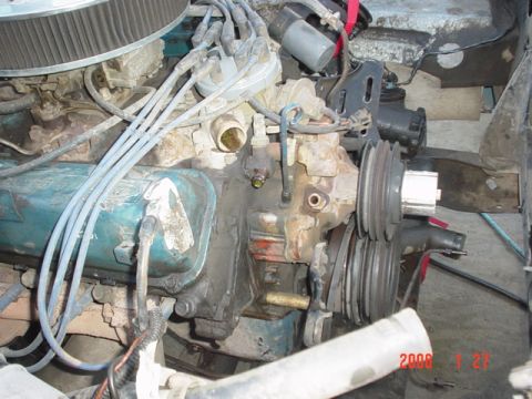 1979 Ford Bronco - Close-up view of an engine compartment, showing various components like the distributor, spark plug wires, and pulleys.