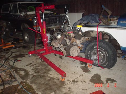 1979 Ford Bronco - Engine removal in progress for a 1979 Ford Bronco, another Bronco visible in the garage.