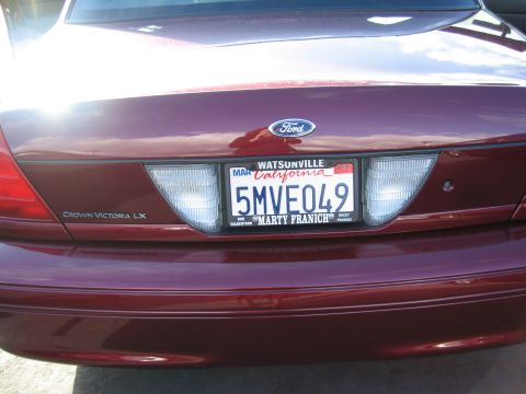 2005 Ford Crown Victoria - Rear view of a maroon 2005 Ford Crown Victoria LX, showing the Ford emblem and license plate.
