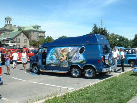 1978 Ford Mustang II - Custom van with mural and dual rear wheels parked at an outdoor event.