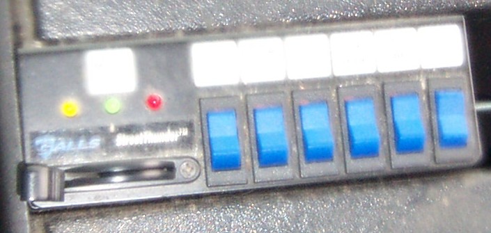 Control panel with six blue toggle switches and indicator lights