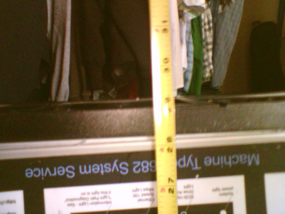 Blurry tape measure held vertically against a machine labeled Type 582 System Service