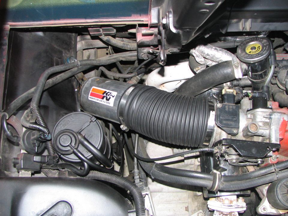 Engine bay detail showing K&N high flow air filter intake tube and various hoses and sensors