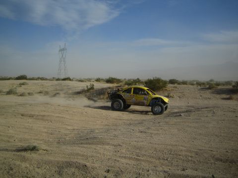 Yellow Beetle-bodied off-road buggy on a sandy desert track