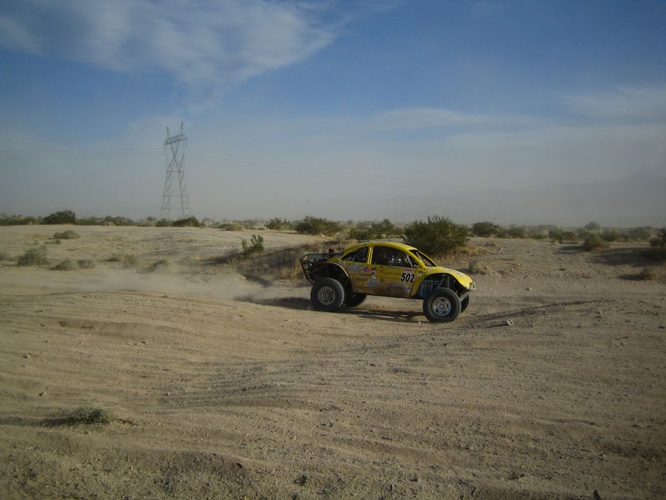 Yellow Beetle-bodied off-road buggy on a sandy desert track