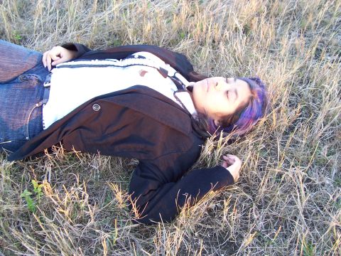 1994 Ford Probe - A person is resting in a field of dry grass.