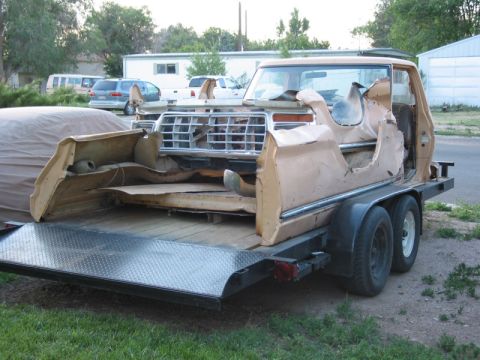 1981 Ford Bronco - A dismantled Ford F-Series truck body is being transported on a flatbed trailer.