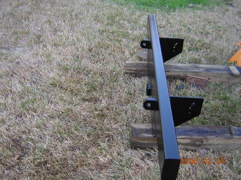 1986 Chevrolet Blazer - A black metal bumper with mounting brackets is shown outdoors, resting on wooden beams.