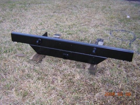 1986 Chevrolet Blazer - A black bumper with visible latches is shown resting on wooden blocks outdoors.