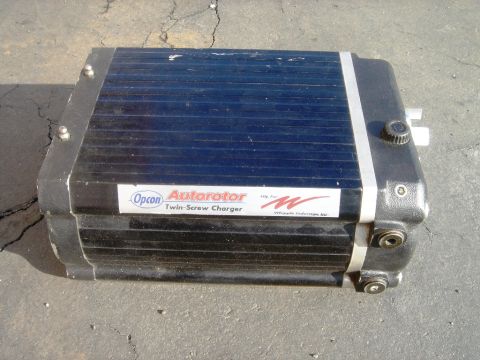 1991 Ford Taurus - Opcon Autorotor Twin-Screw Charger part shown outdoors on cracked pavement.