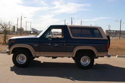 1986 Ford Bronco - This Ford Bronco SUV is seen from the side, with a dark blue body and tan accents.