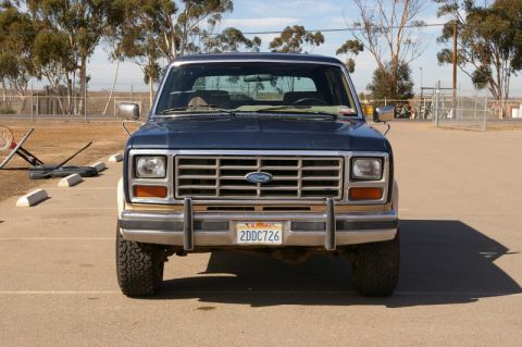 1986 Ford Bronco - This Ford Bronco is parked in an outdoor lot with a basketball hoop in the background.