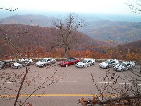 1994 Ford Probe - Cars parked at a scenic overlook during autumn, with mountains in the distance.