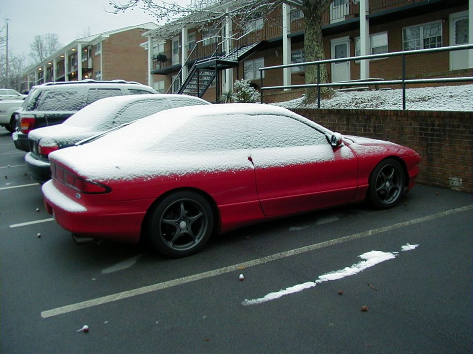 Red 1997 Ford Probe parked in snow, side view