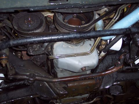 2001 Ford Crown Victoria - Underside view of vehicle engine and suspension components, showing oil pan, pulleys, and steering linkage.