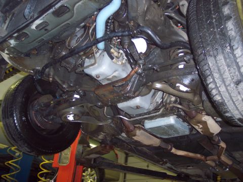 2001 Ford Crown Victoria - The underside of a vehicle is shown, revealing its mechanical components and suspension system.