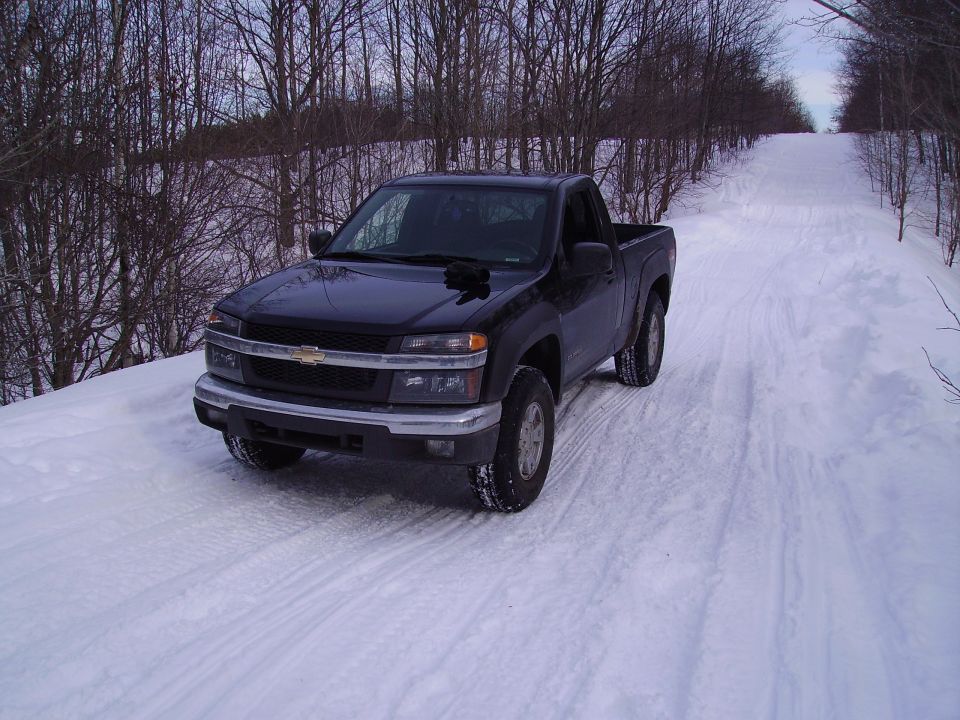 Black Chevrolet Colorado pickup truck parked on a snowy road