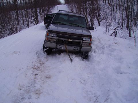 2000 Chevrolet Tahoe - A gray Chevrolet Tahoe is stuck in a snowy area, with another vehicle visible behind it.