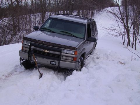 2000 Chevrolet Tahoe - This Chevrolet Tahoe is stuck in the snow, with an axe lodged in front of it on a winter day.