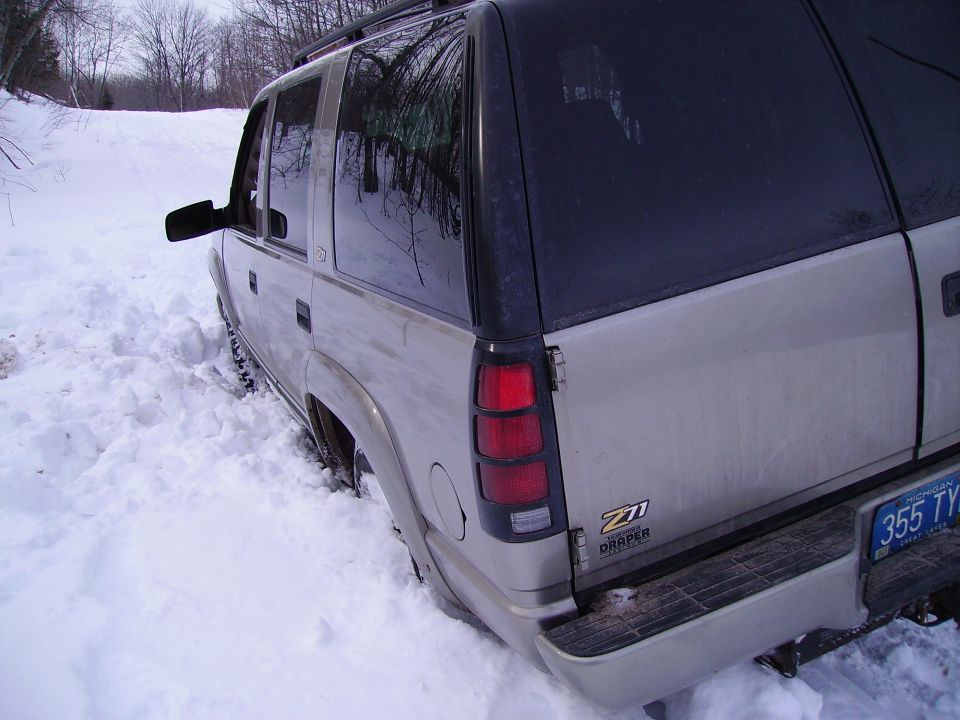 Rear 3/4 view of a silver SUV stuck in snow, showing Z71 badging
