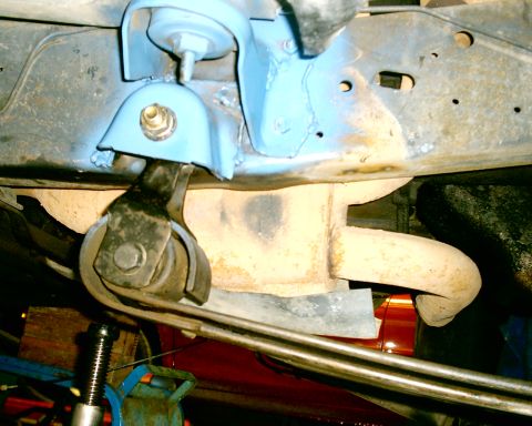 1985 Ford Bronco - Close-up view of exhaust pipe and suspension components, with visible text "SUPERMOTORS" at the bottom right.