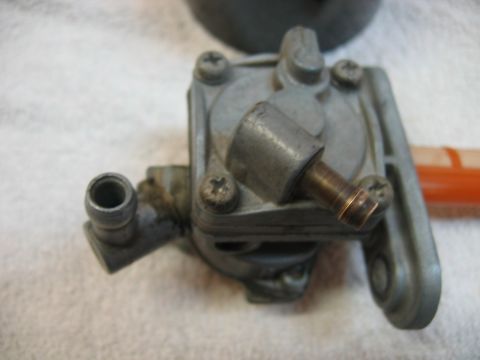 1985 Ford LTD Crown Victoria - A close-up view of a metal fuel petcock, likely for a motorcycle or small engine.