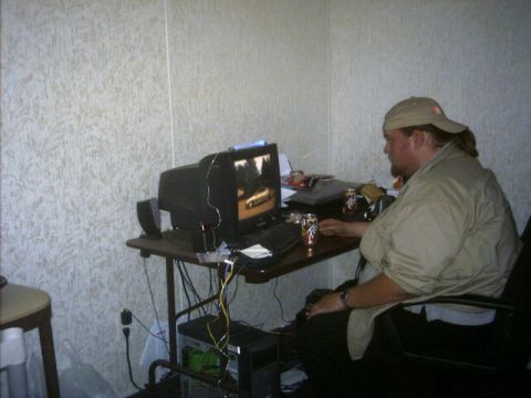1985 Ford Crown Victoria LTD - Man plays a video game on a computer, with a racing scene displayed on the monitor.