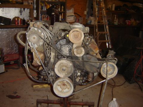 1992 Ford Bronco - Engine assembly with visible pulleys and belts, set up in a workshop environment.