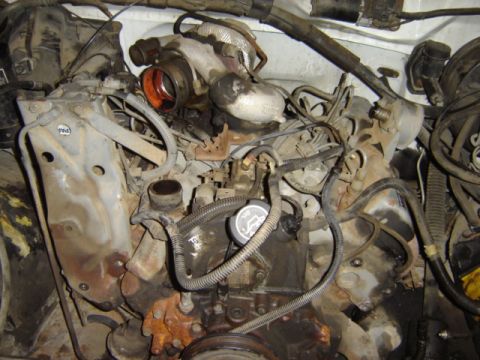 1992 Ford Bronco - Engine bay detail with turbocharger and associated plumbing. Oil cap is present.