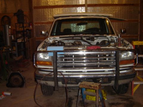 1992 Ford Bronco - Front view of a 1992 Ford Bronco in a garage, hood open, with a brush guard.