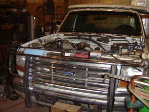 1992 Ford Bronco - White 1992 Ford Bronco with its hood open, showing the engine compartment and front grille.