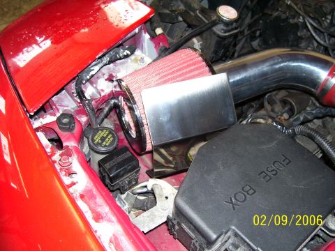 1994 Ford Probe - Close-up of a vehicle's engine bay, showing an aftermarket air intake system and fuse box.