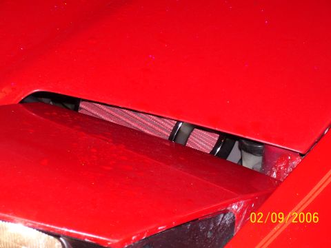 1994 Ford Probe - Close-up of a red car's engine bay, showing an aftermarket air filter.