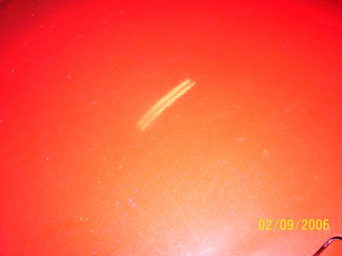 1994 Ford Probe - Close-up of orange car paint showing a scratch, dated 02/09/2006.