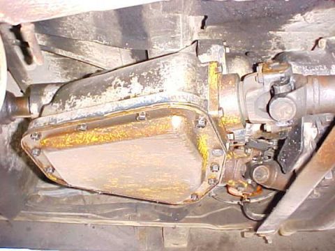 2000 Ford E350 - Underside view of a transmission pan and driveshaft assembly, with visible rust and wear.