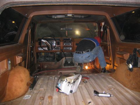 1978 Ford Bronco - Interior view of a 1978 Ford Bronco, showing the dashboard and a person working on it.