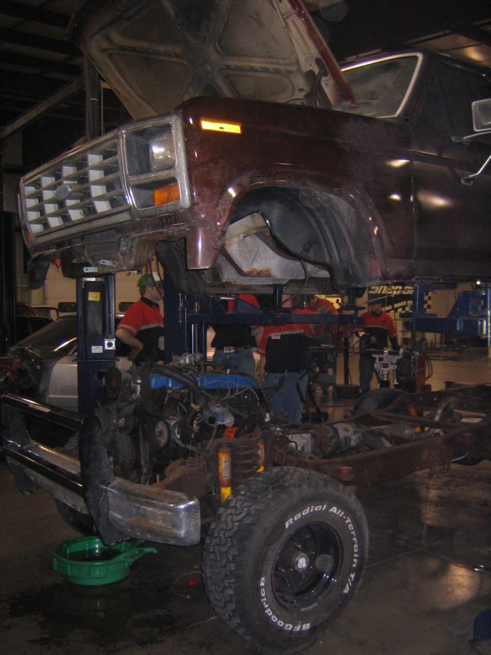 1978 Ford Bronco chassis on lift, engine exposed, front clip attached