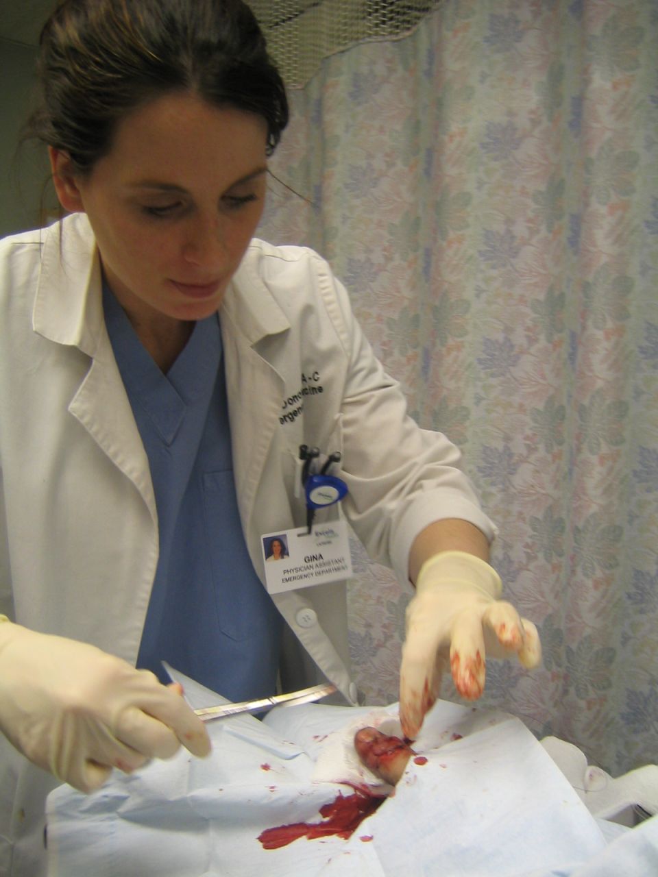 Medical professional performing a procedure with bloody gauze and surgical tools