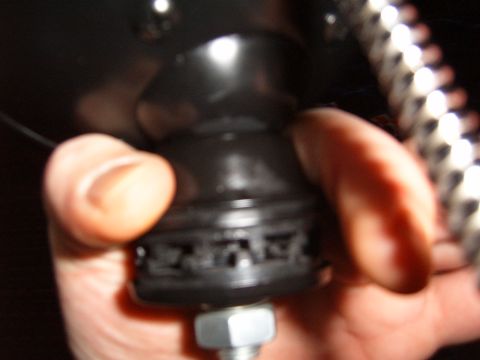 1993 Ford Bronco - A hand holds a black rubber part with a metal bolt and nut.