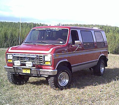 2000 Ford E350 - This red van, likely a 1992 model, is equipped with chrome trim and off-road tires, suggesting it's ready for adventure.