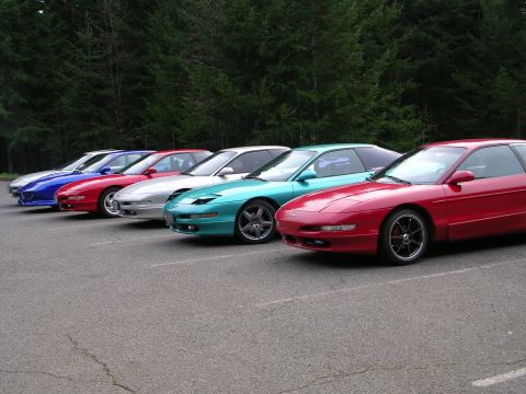 1996 Ford Probe - A line of Ford Probe coupes, including a red one in the foreground, are parked in a lot.