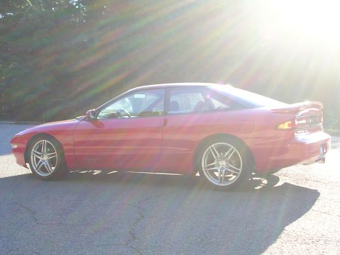 1996 Ford Probe - A red 1996 Ford Probe is parked outside on a sunny day.