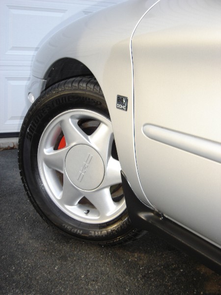 1999 Ford Taurus - Close-up of a 1999 Ford Taurus wheel and fender, showing the '24V DOHC' badge.