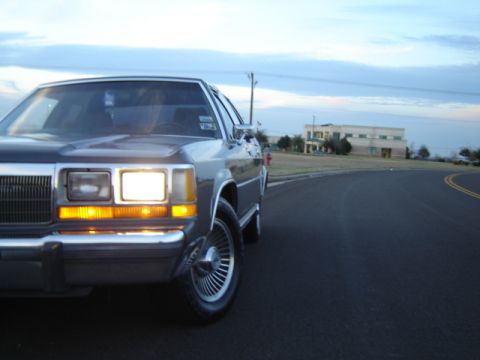 1988 Ford Crown Victoria LTD parked on a road with a building in the background