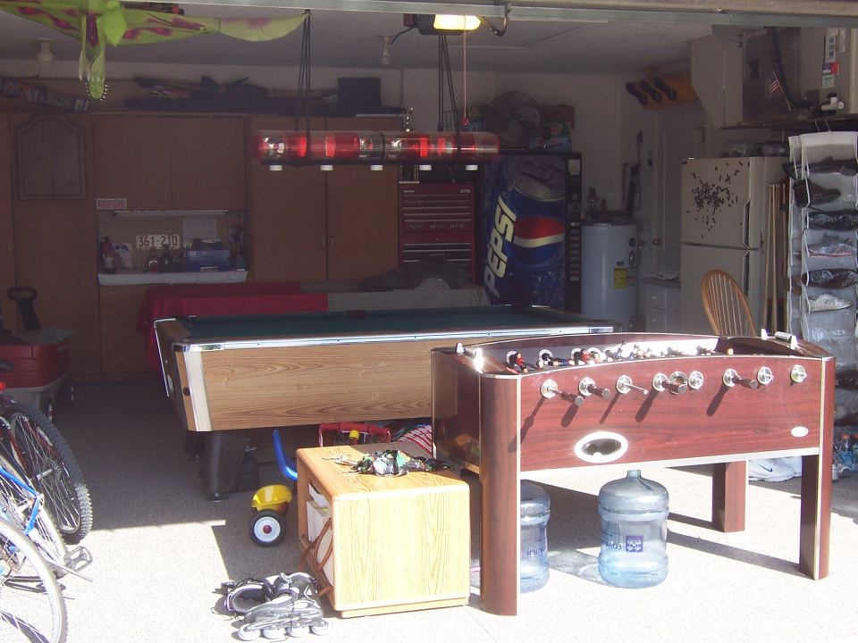 Garage interior with pool table, foosball table, Pepsi machine, and bicycles